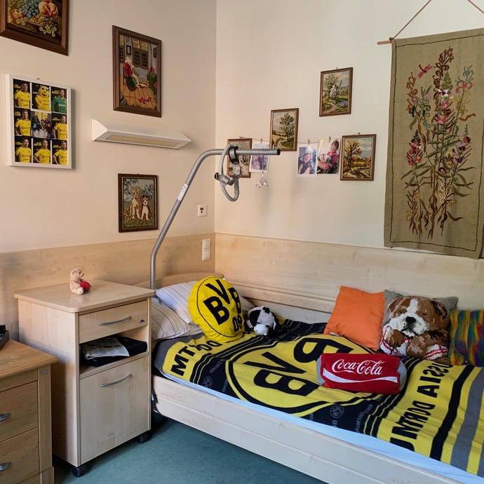 Blick in ein schwarz-gelb geschmücktes Zimmer mit zahlreiche Abbildungen von Fußballern an der Wand (vergrößerte Bildansicht wird geöffnet)